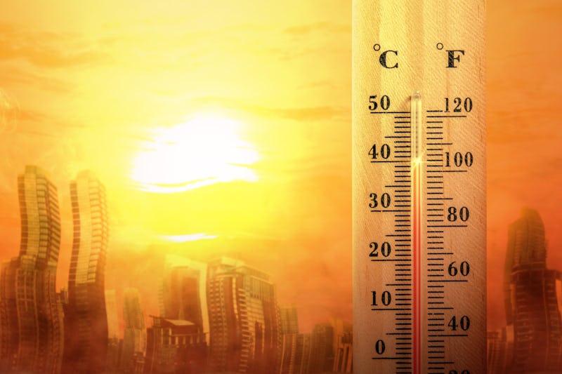 Thermostat rising to high temperature against sun and melting city backdrop