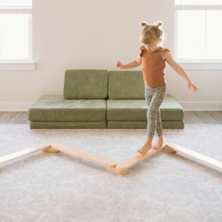 A little girl walking on a wooden climbing toy
