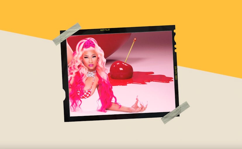 Nicki Minaj with a pink up do laying down with a massive cherry melting in the background
