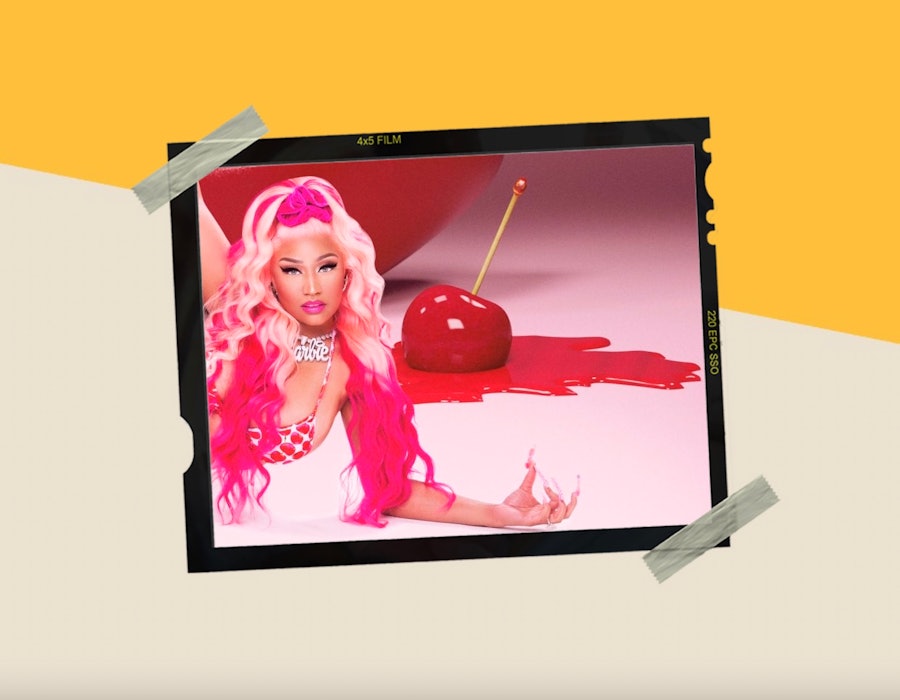 Nicki Minaj with a pink up do laying down with a massive cherry melting in the background