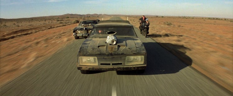 Two cars and a motorcycle on a desert road