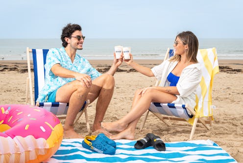 A couple drinking pumpkin spice latte on a beach