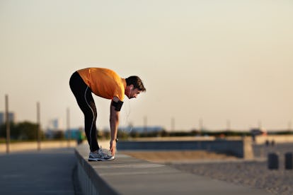 Die beste Stretching-Routine für Männer, in 15 Dehnungen 1 Ein flüchtender Mann beugt sich über die Hüften, um seine Zehen zu berühren.