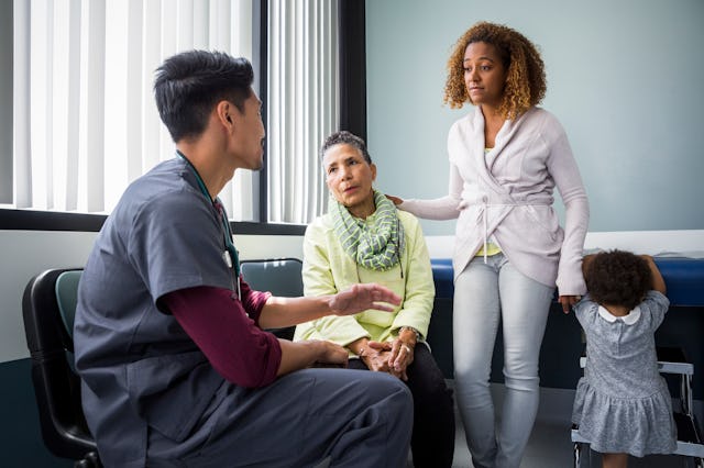 A woman and her mother speak with a male nurse.