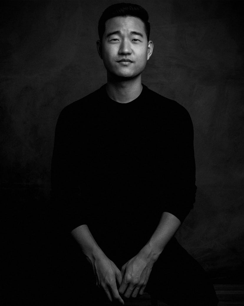 A portrait of Daniel K. Isaac with a neutral facial expression in black and white