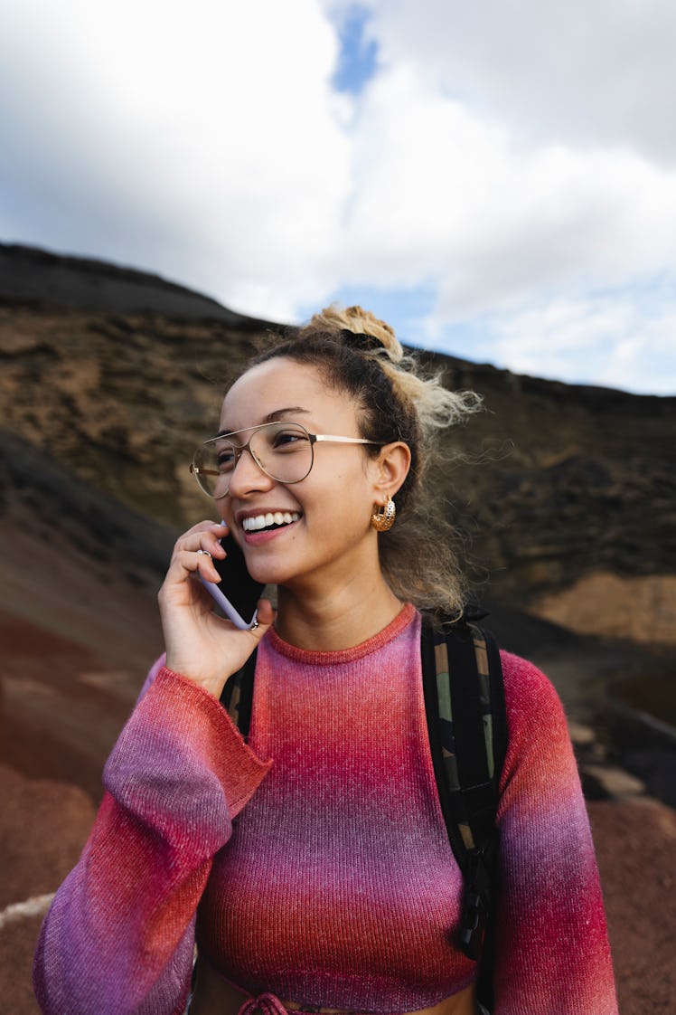 Young woman on her cell phone on the luckiest day in September 2022 for every zodiac sign.