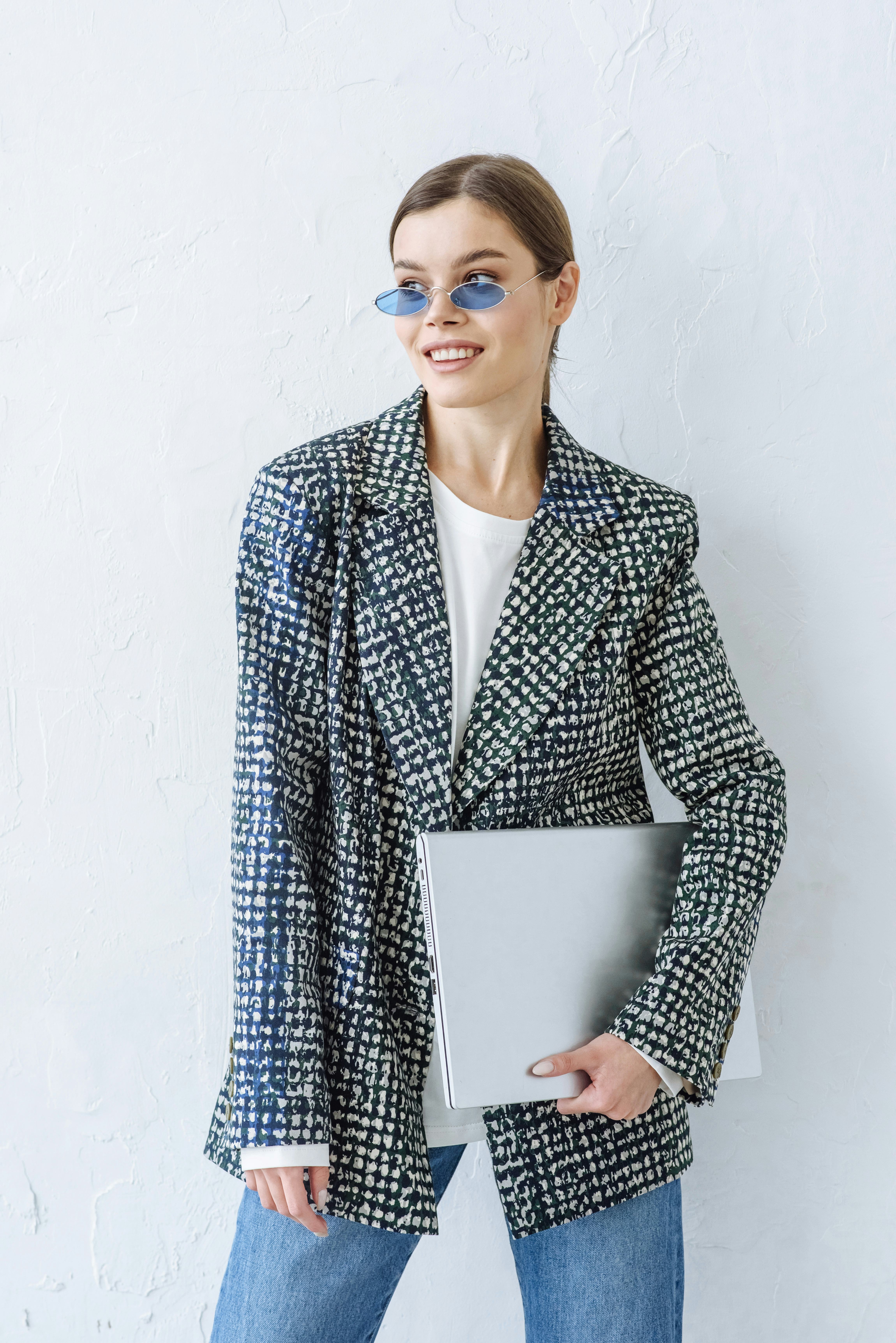 Young woman holding her laptop as one of the luckiest zodiac signs of September 2022.