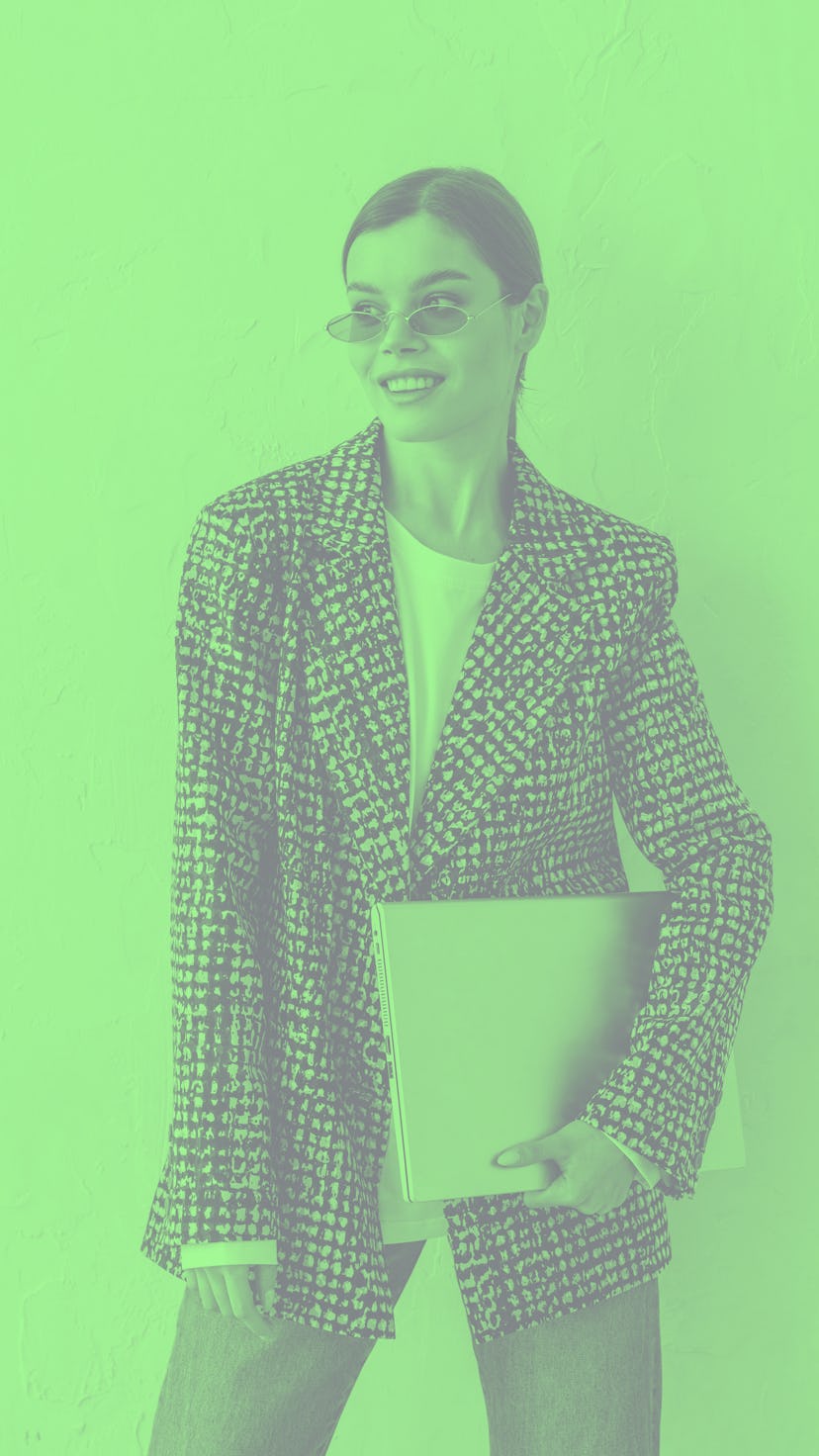 Young woman holding her laptop as one of the luckiest zodiac signs of September 2022.