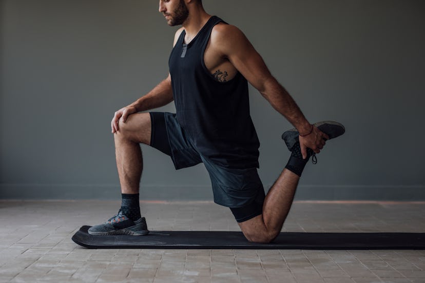 A man doing a lunge variation stretch.