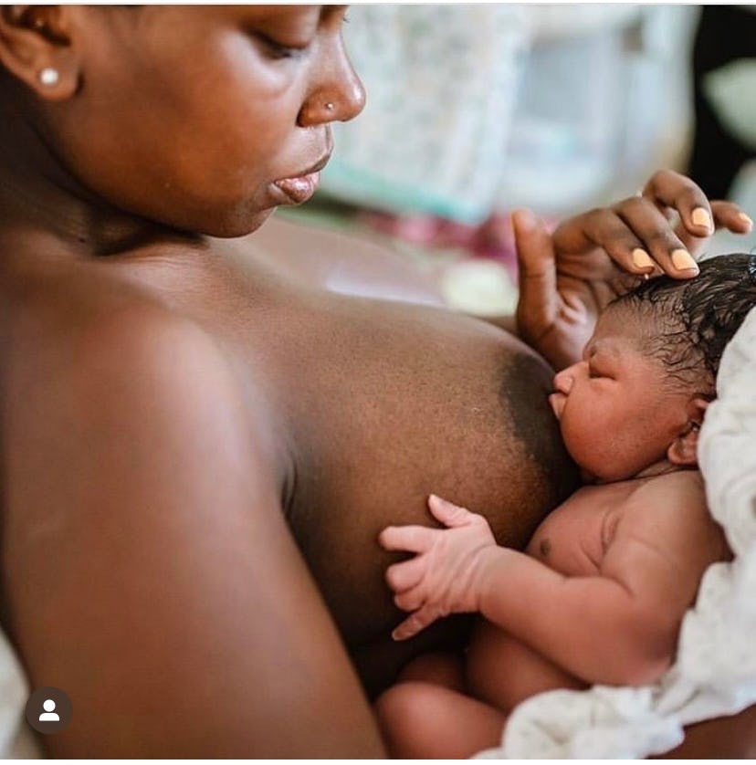 Black mother is skin to skin breastfeeding her newborn baby