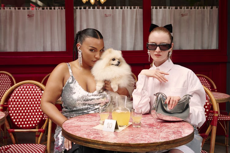 A girl wearing a glittery disco dress and holding a puppy, while another girl wears sunglasses and a...
