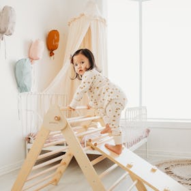 A toddler climbs on the Piccalio mini climber set 
