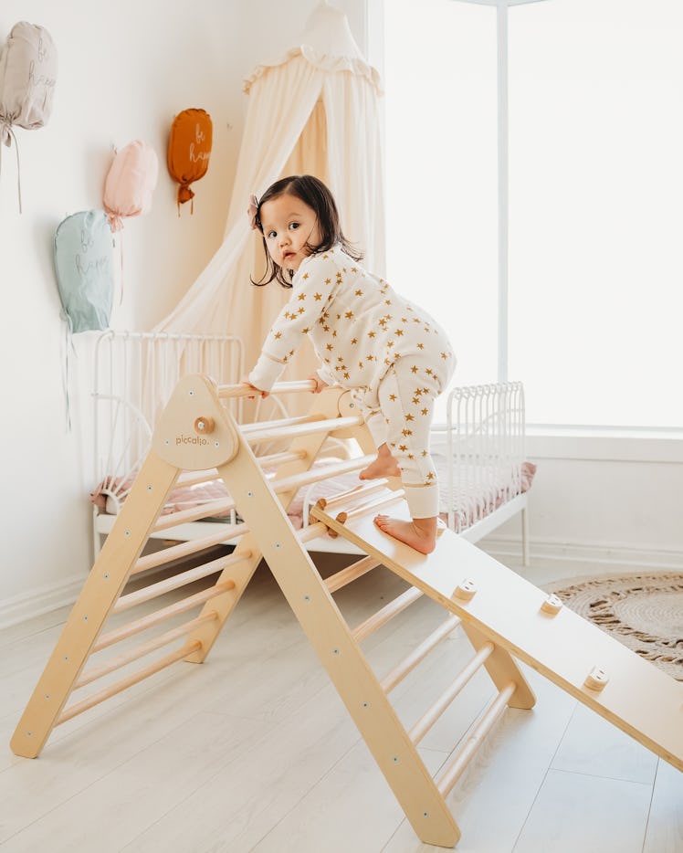A toddler climbs on the Piccalio mini climber set