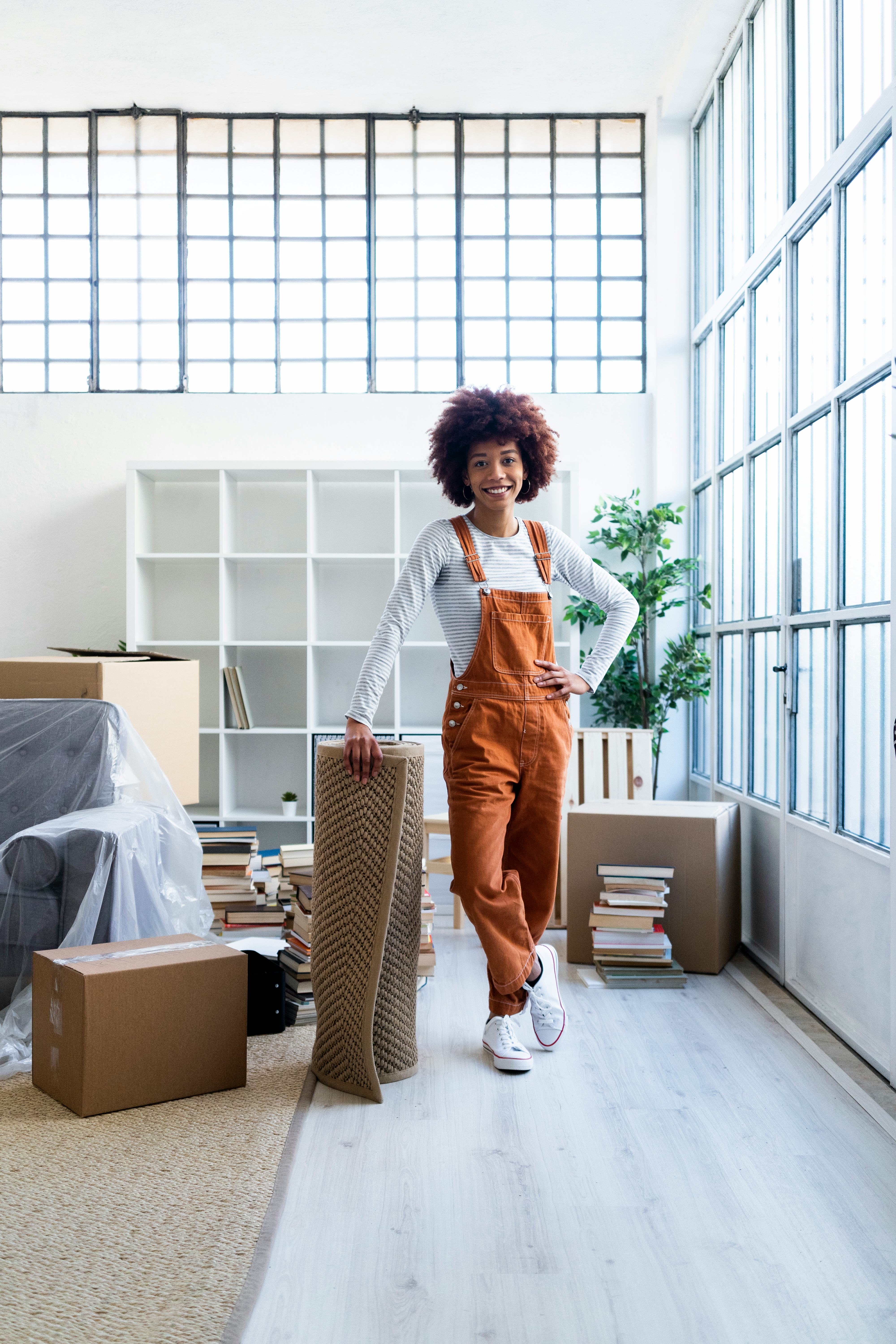 Young woman standing in her new apartment during the August 2022 new moon in Virgo.