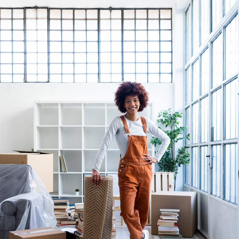Young woman standing in her new apartment during the August 2022 new moon in Virgo.