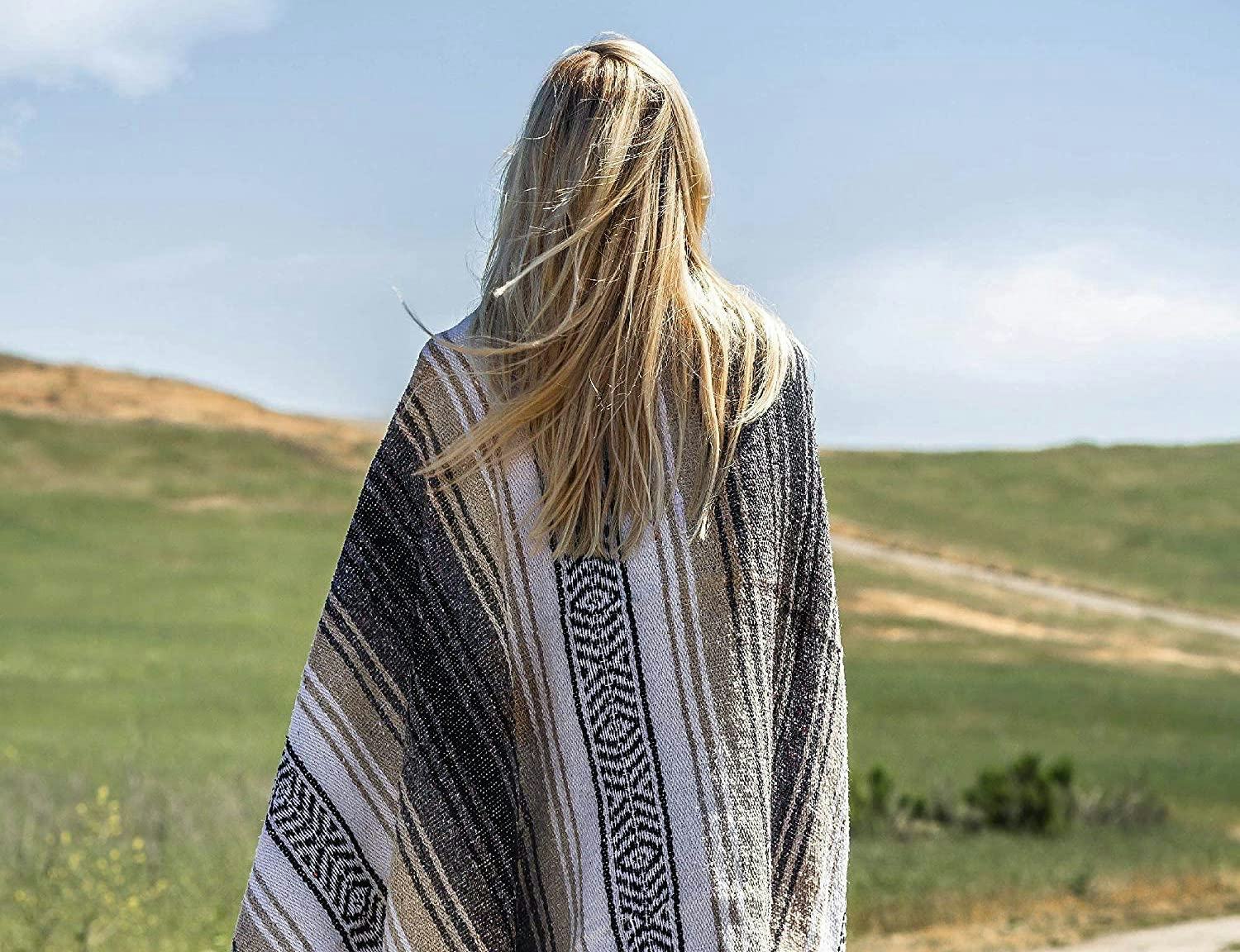 The best outdoor blankets are comfy to use, like the one that appears in this photo of a person with...