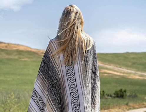 The best outdoor blankets are comfy to use, like the one that appears in this photo of a person with...