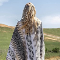 The best outdoor blankets are comfy to use, like the one that appears in this photo of a person with...