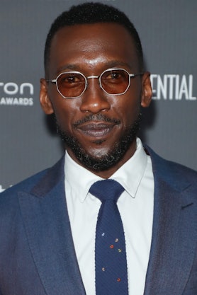  Mahershala Ali wearing tinted shades and a blue suit with a blue tie, and a white button-up at a re...