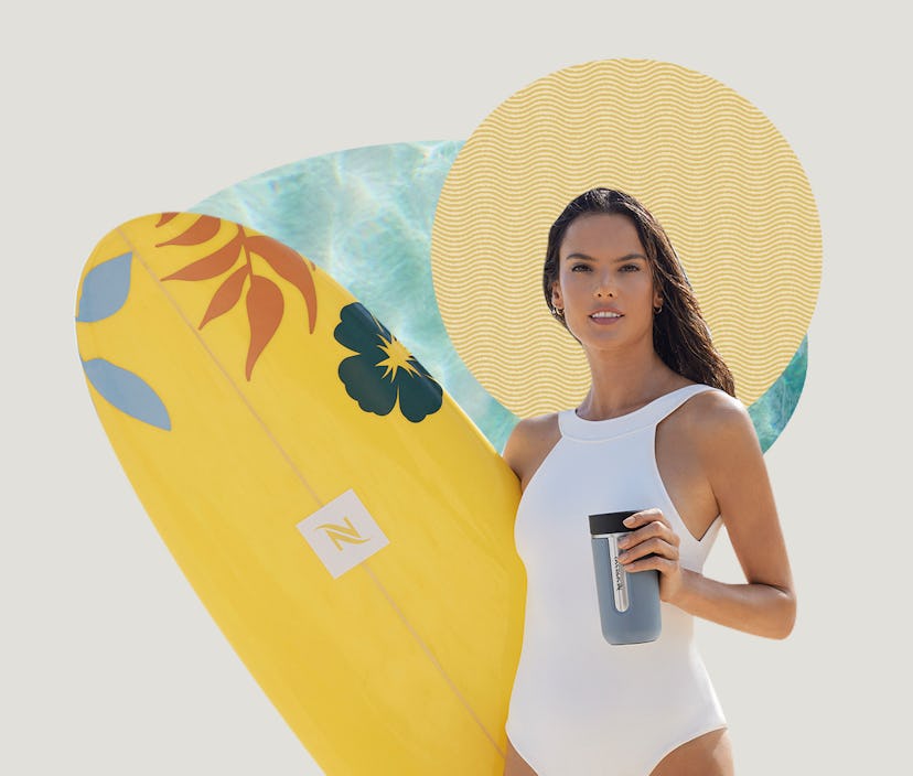Alessandra Ambrosio holding the Nespresso Nomad Travel Mug and a surfboard.