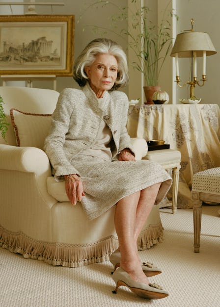 The elegant socialite Deeda Blair wearing a cream colored suit on a cream colored armchair in a crea...