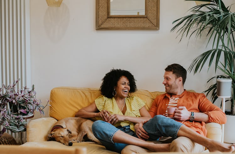 Happy couple sitting on couch and laughing