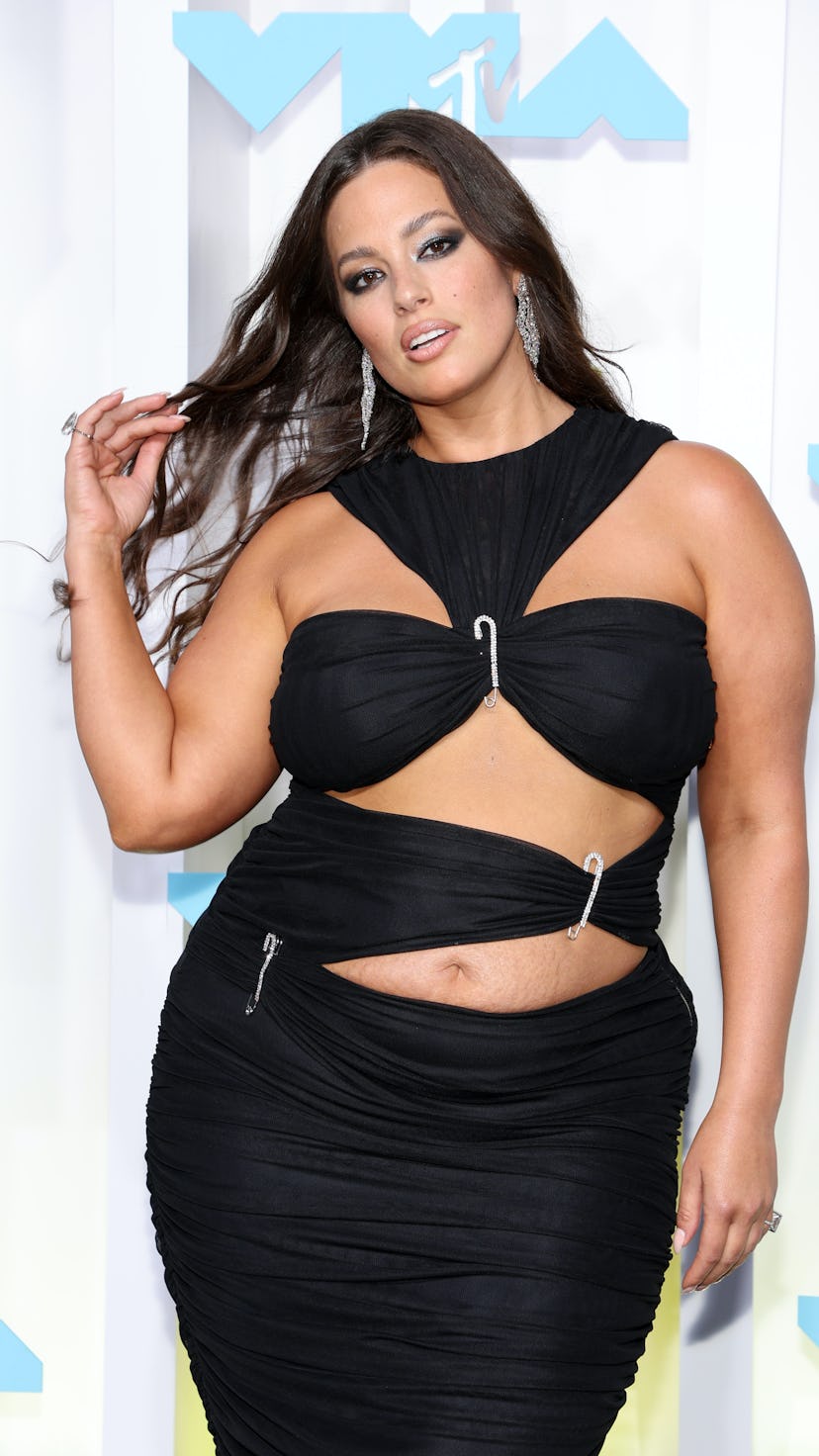 Ashley Graham posing in a black dress