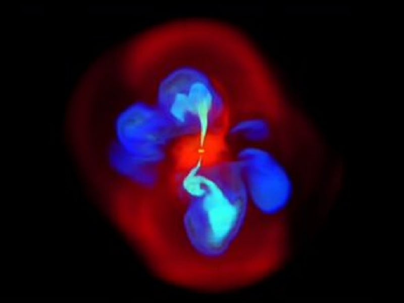 Image of a simulated supermassive black hole in reds and blues on a black background.