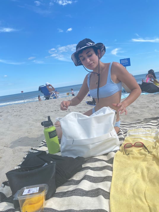 A girl with her F.A.R. essentials on the beach