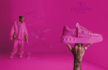 Lewis Hamilton pictured in a bright pink Valentino campaign next to a sneaker