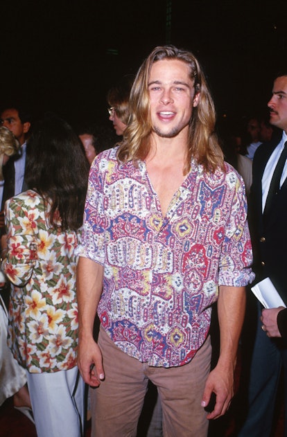 A long-haired Brad Pitt wearing a colorful paisley button-down