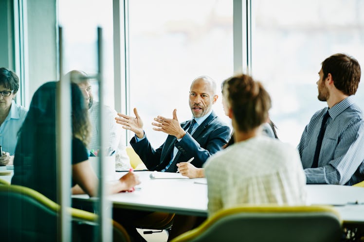 A manager mansplaining to others at a meeting at the office.