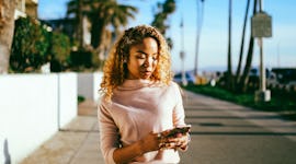 Young woman texting in the ideal solo travel destination for her zodiac sign in summer 2022.
