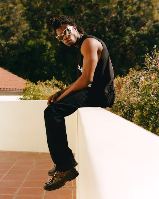 Obongjayar photographed in Los Angeles in a black tank top and black pants and silver sunglasses
