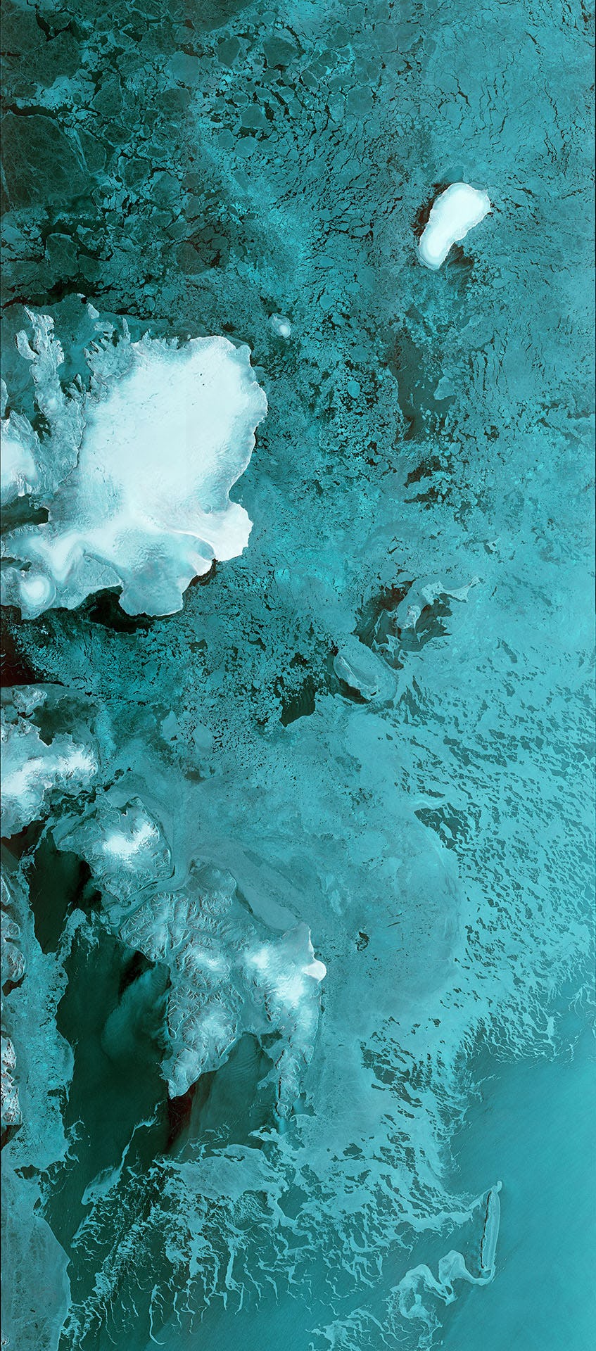 Satellite shot of the Barents Sea and Svalbard archipelago in rich teals and blues.