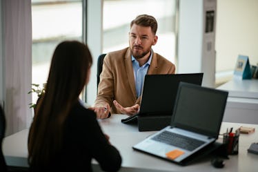 A man talking to his co-worker about resigning