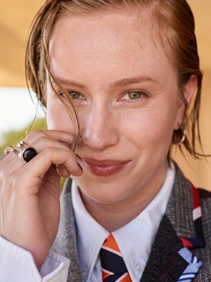 Hannah Einbinder in Thom Brown clothing and tie, Jennifer Fisher earrings, Khiry ring, Third Crown r...