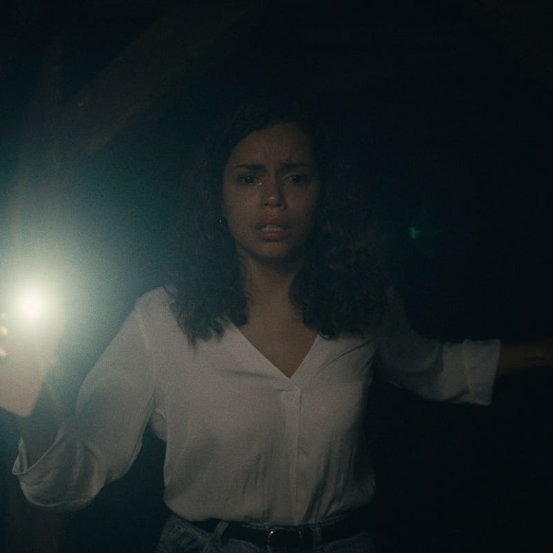 A woman in Barbarian walking in the dark and using her phone light
