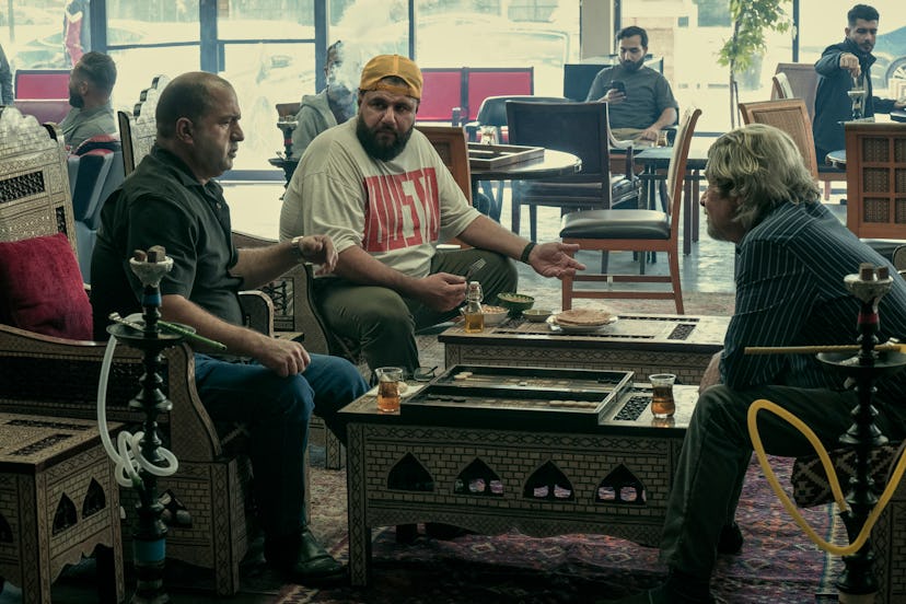 Mo Amer sitting in a shisha bar with two men