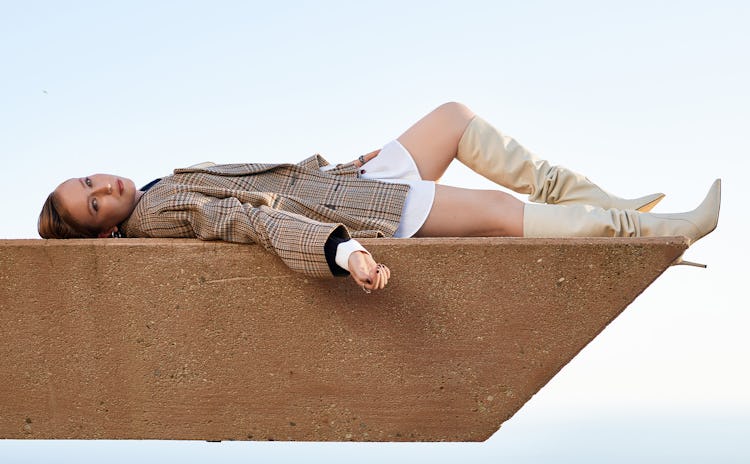 Hannah Einbinder laying on a photo shoot in the newest Miu Miu collection