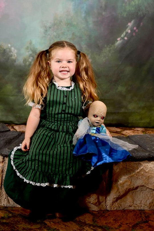 Briar sits in a studio with a frightening doll, Creepy Chloe, beside her wearing a fancy princess dr...