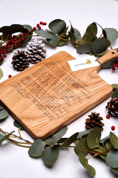 Personalized cutting board laying on a fall wreath is a great grandparents day gift.