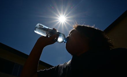 A child sips water from a bottle under a scorching sun on Aug. 30, 2022, in Los Angeles, California.