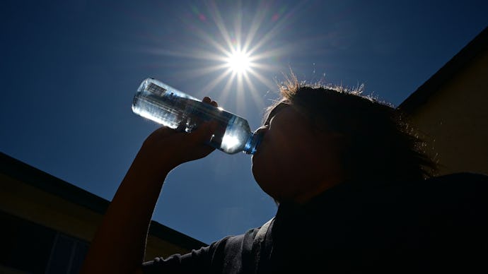 A child sips water from a bottle under a scorching sun on Aug. 30, 2022, in Los Angeles, California.