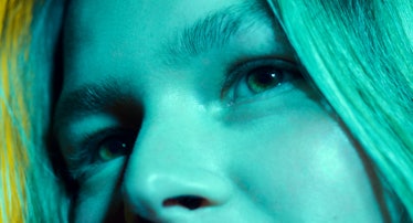 An up close shot of model's face bathed in blue light