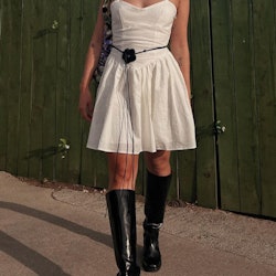 Tall boots styled with a short white dress