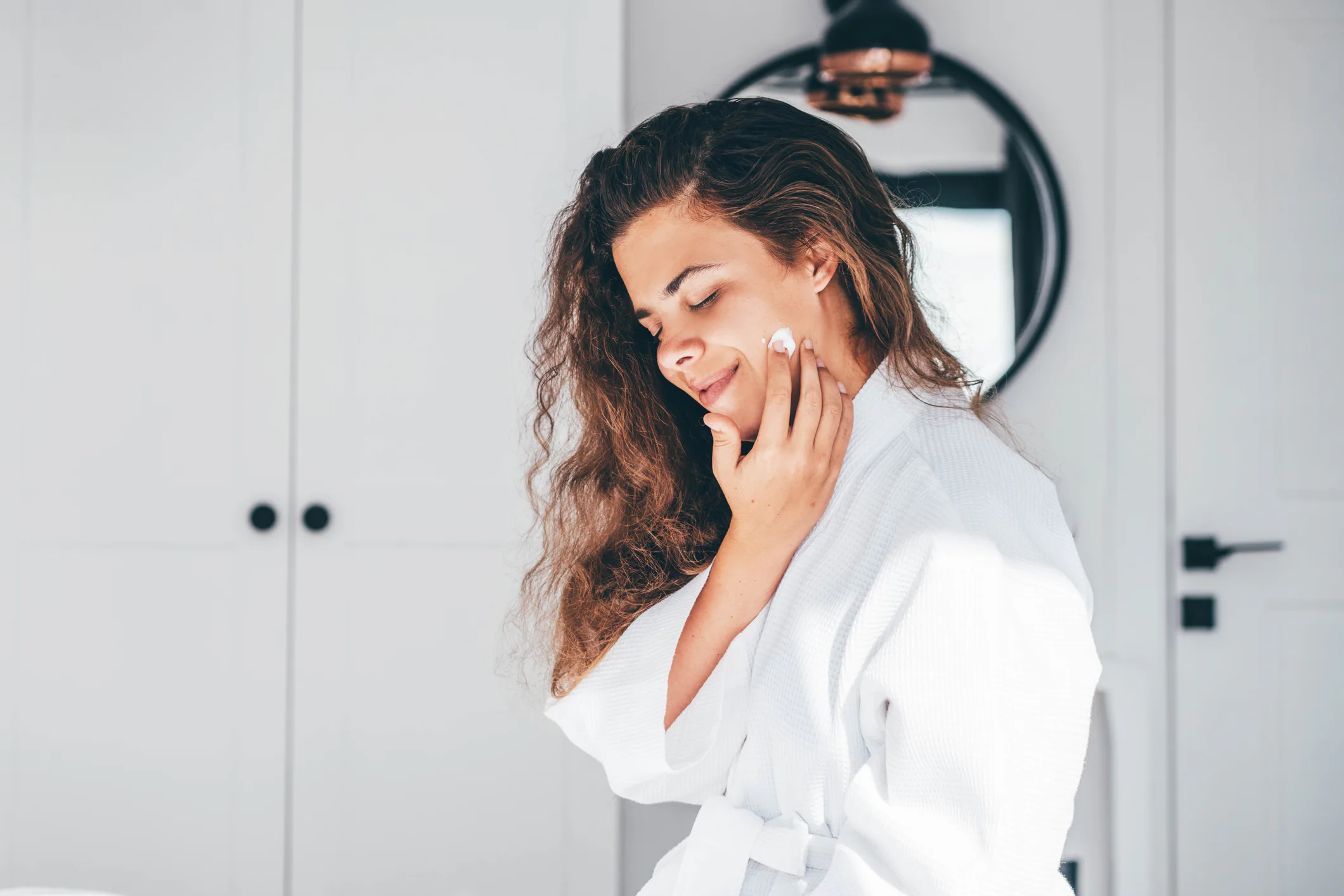 woman applying face cream for rosacea