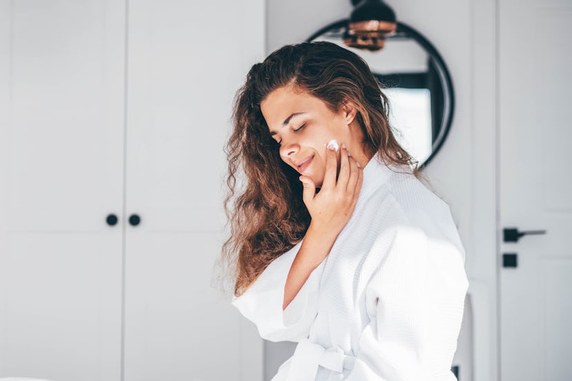 A woman applying face cream for rosacea