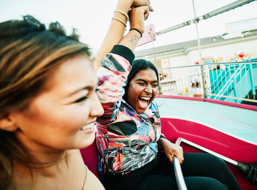 Young friends at an amusement park after reading their August 15, 2022 weekly horoscope.