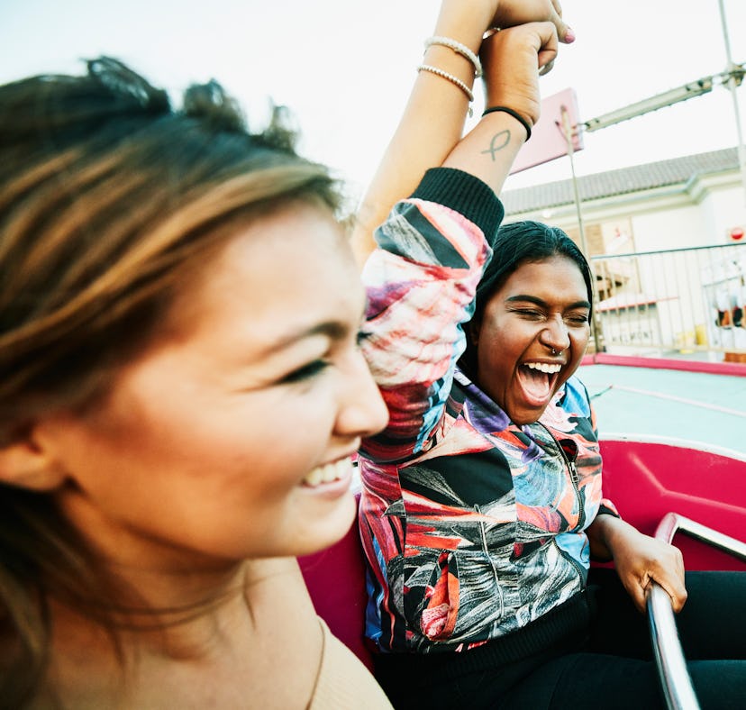 Young friends at an amusement park after reading their August 15, 2022 weekly horoscope.